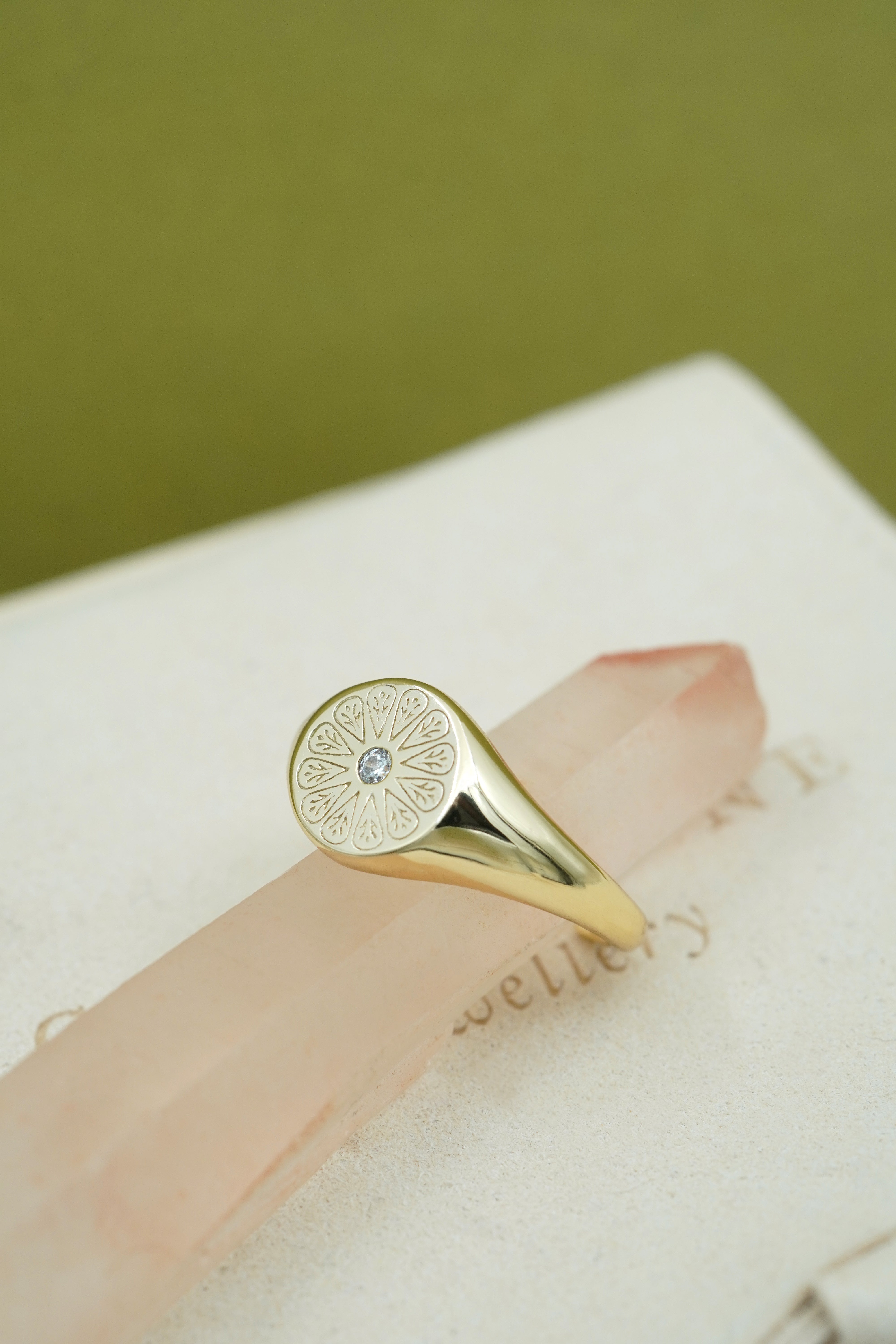 Gold April Birthstone Ring on pink crystal