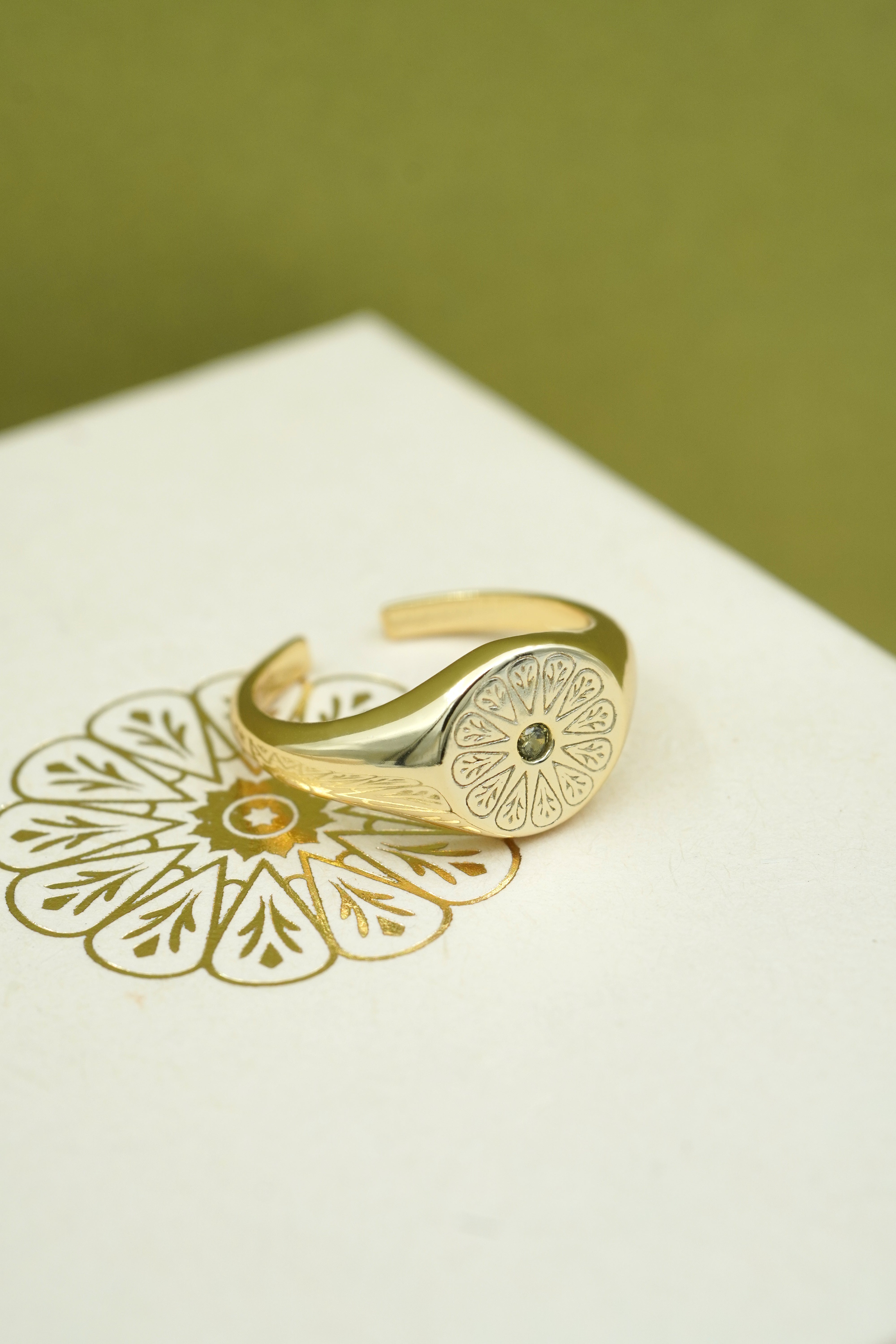 August Peridot Birthstone Signet Ring in gold on cream box with logo