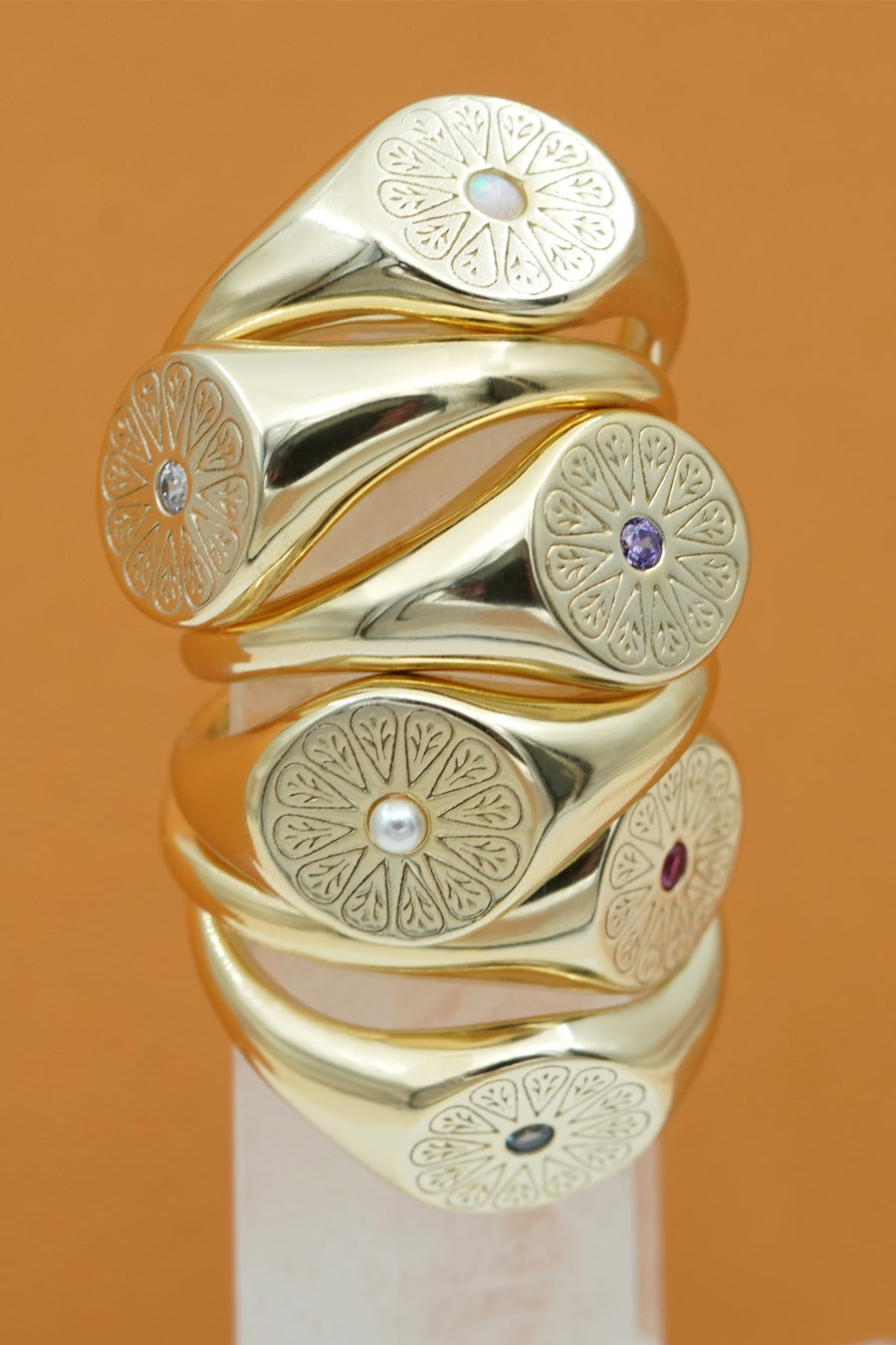 Gold May Birthstone Rings stacked with other rings
