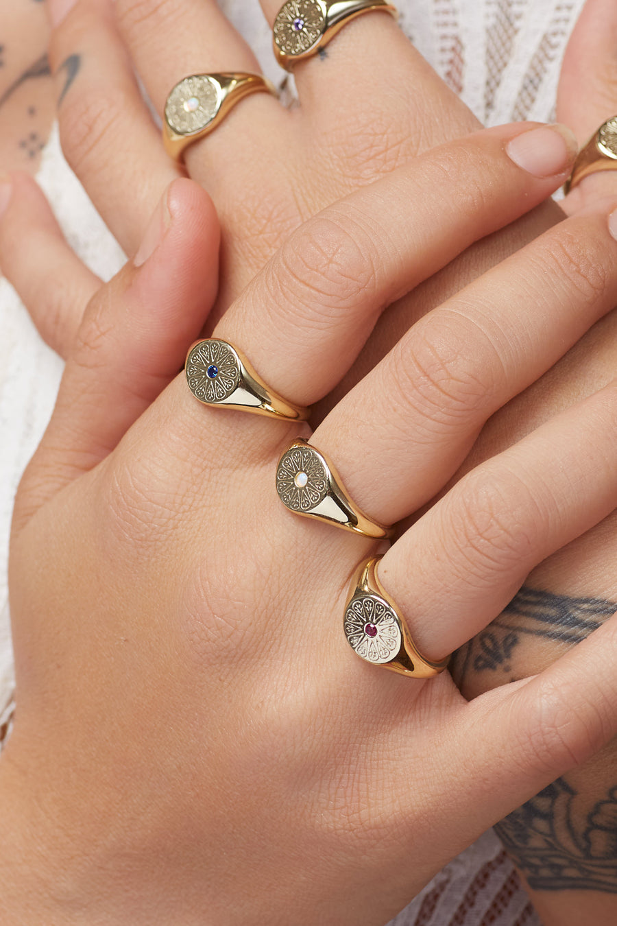 Gold Birthstone Signed Rings stacked on hand