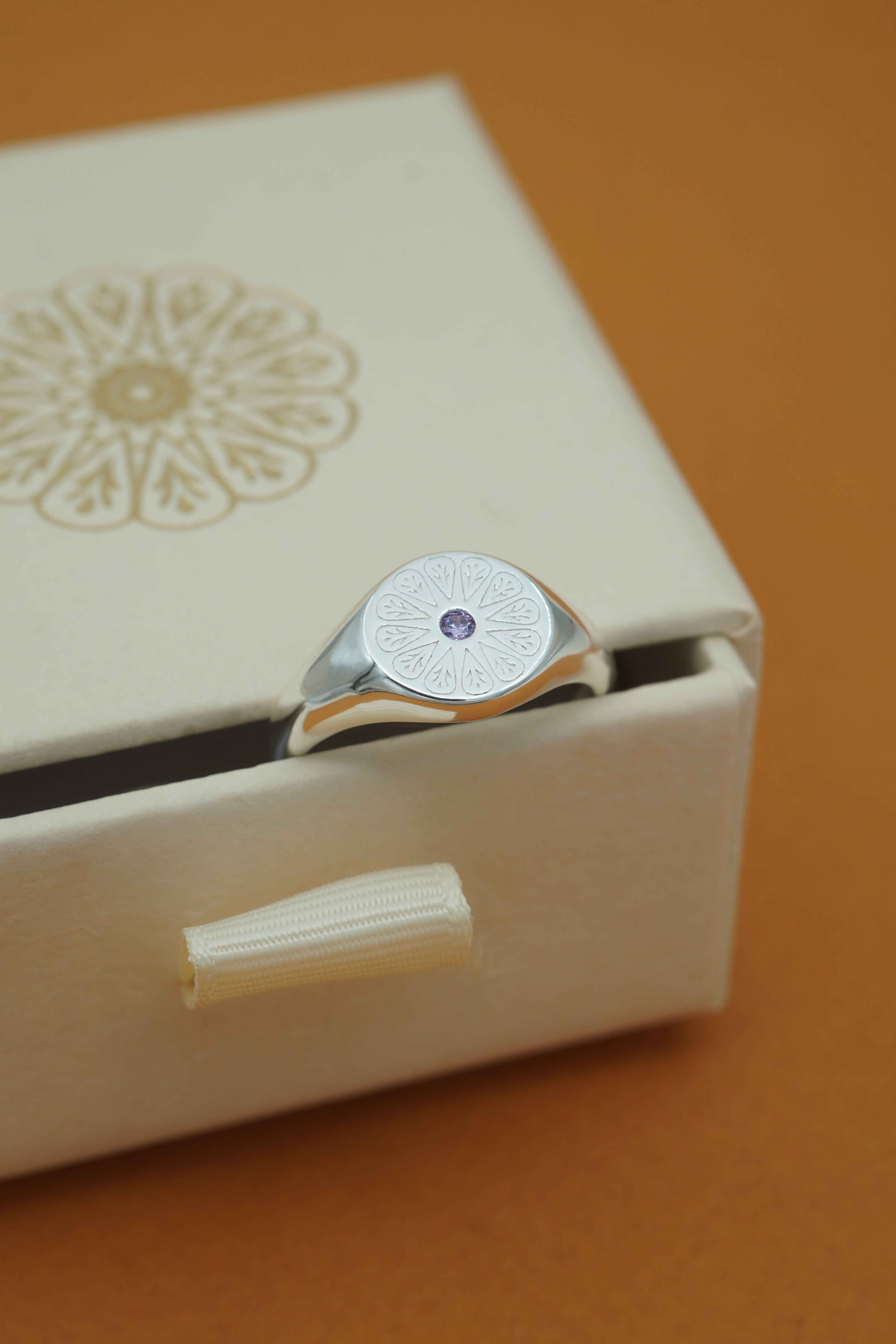 Silver Amethyst Birthstone Signet Ring on cream box