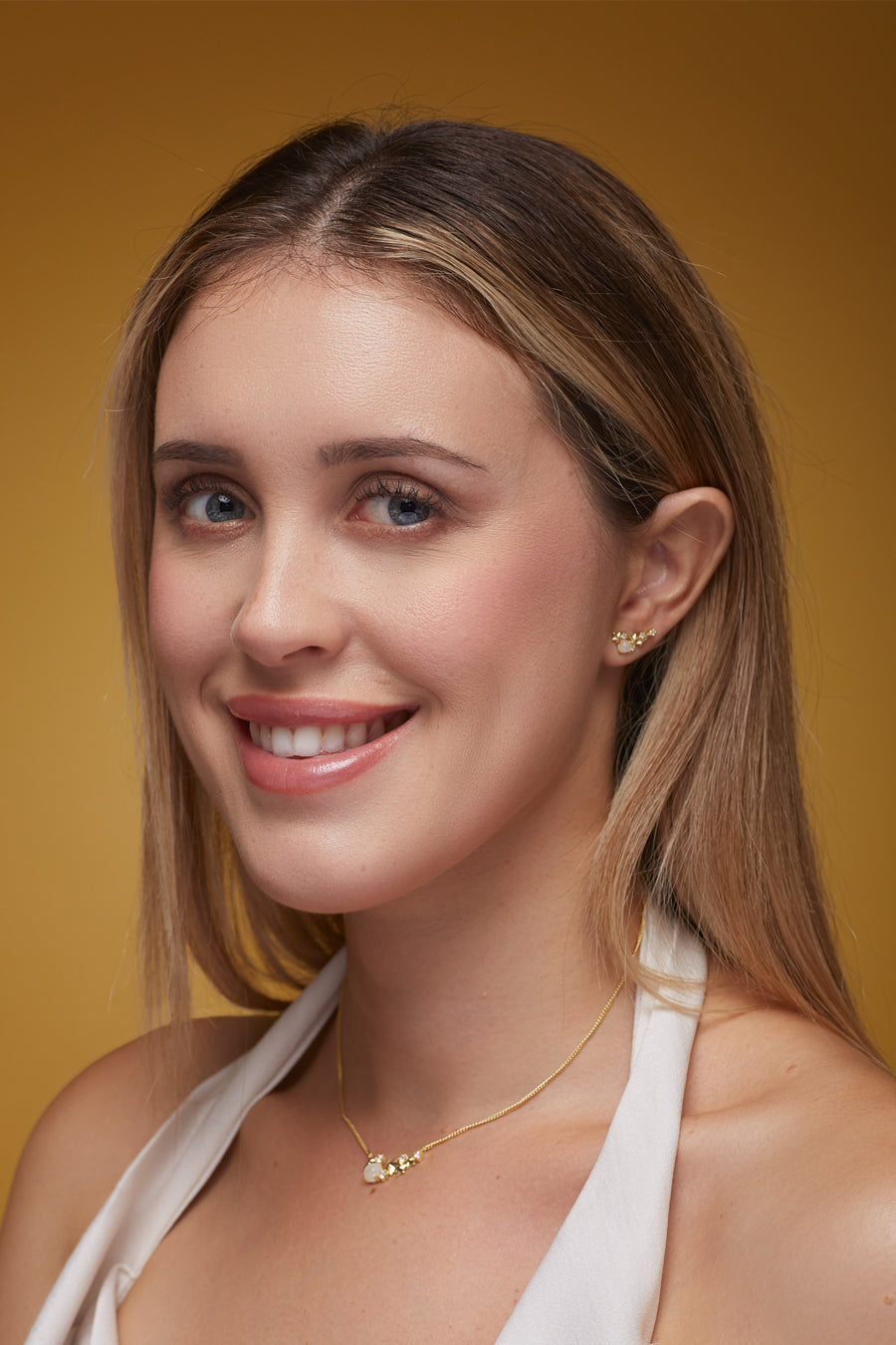 Matariki Jewellery worn on girl on mustard coloured background